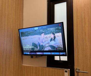 Smart TV di kamar Kos Si Bos Surabaya Barat lengkap dengan akses Netflix untuk hiburan penghuni.