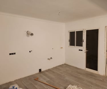 a room with a lot of white walls and a window