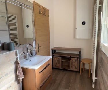 Salle de bains avec grand chauffe-eau et sèche-serviettes fonctionnel.