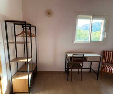 Chambre avec dressing, bureau et fauteuil.