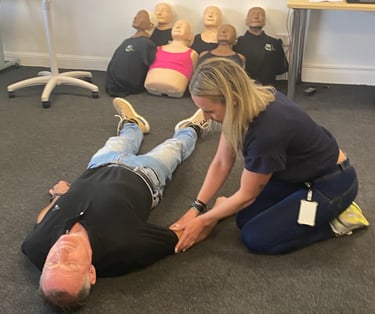 First aid learner practising CPR and casualty assessment skills on a person during training