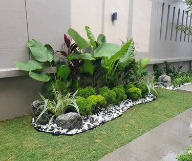 Tropical garden bed with white pebbles and artificial turf – Yie Yang Landscape