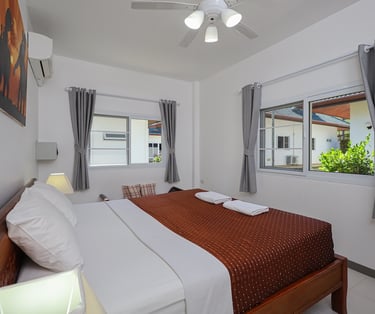 Master bedroom with king size bed and air conditioning at Yanui Apartments