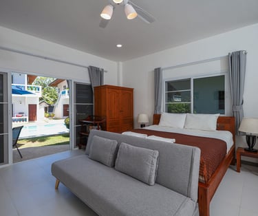 Modern studio apartment interior with king bed and seating area