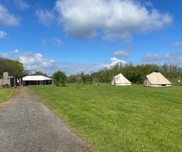 Empty bell tents and some of the camping area