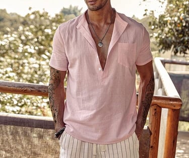 a man in a pink beach style shirt and white shorts