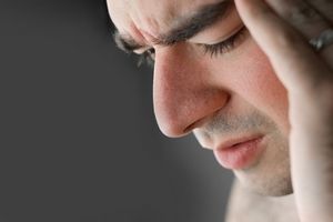 Homme souffrant, main sur le visage, soulager douleur chronique et fibromyalgie, avec l'hypnose.