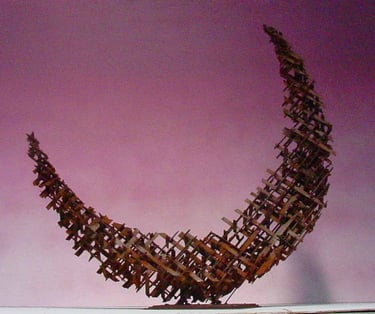 a rusted steel cross-hatched crescent shaped sculpture