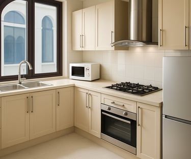 Modern cream kitchen cabinets with a stainless steel stove, oven, and refrigerator near a window.