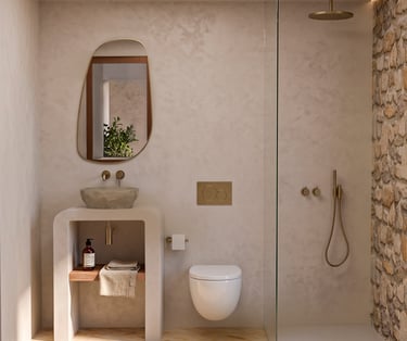 Modern minimalist bathroom with a natural stone vessel sink, gold fixtures, and a walk-in shower with stone walls.