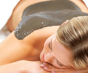 Ghassoul sur le dos d'une femme allongée dans un Hammam
