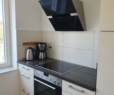 Blick in die Küchenzeile mit Herd, Kaffeemaschine, Wasserkocher