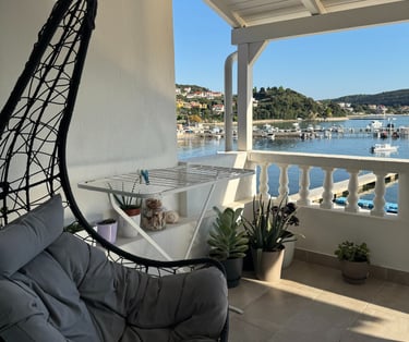 Hängesessel auf einem Balkon mit Blick auf Boote und das Meer in Kampor auf Rab