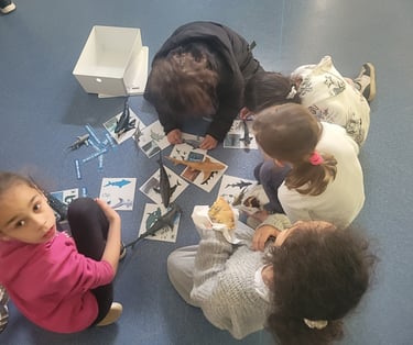 a group of children sitting on the floor in a circle playing with sarks carts game