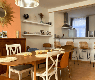 Salle à manger conviviale avec table familiale et cuisine ouverte équipée.