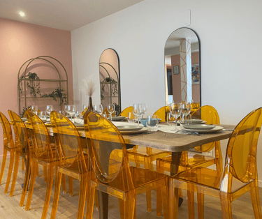 Grande salle à manger d’hébergement équipé avec table et chaises modernes pour repas en groupe.