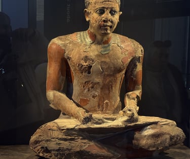 a statue of a man sitting on a rock