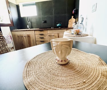 Rustic wooden kitchen with ceramic cup on dining table in seaside villa Siracusa, Sicily