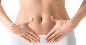 фото жінка тримає руки на животі у білій білизні