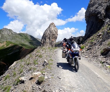 a person riding a motorcycle down a mountain side