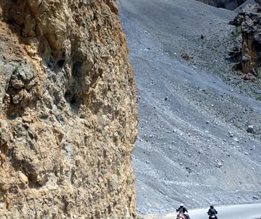 two people riding motorcycles down an alpin mountain side