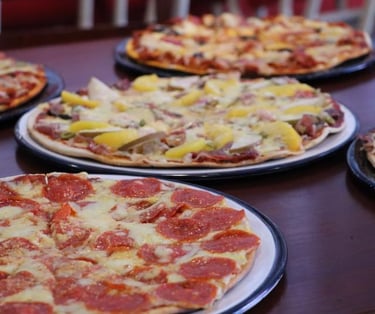 Imagen de pizzas en una mesa