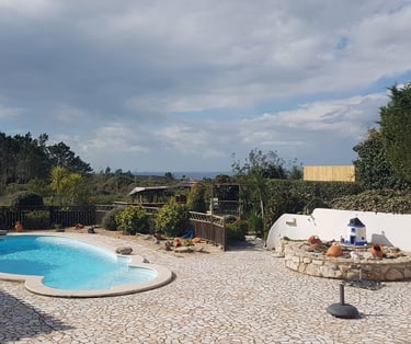 a pool with a stone patio area and sea view