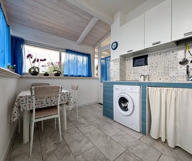 Cucina attrezzata in appartamento vacanze con frigorifero e lavatrice