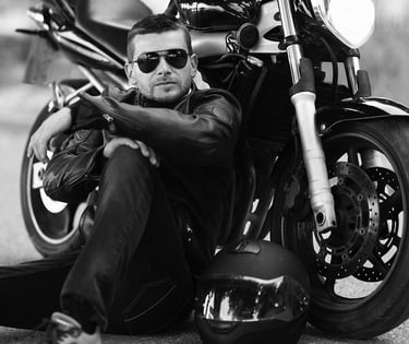 Audrius Turskas - a cool man sitting on the ground next to a motorcycle