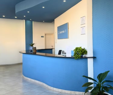 Recepción de la Clínica Bocarriba en El Médano, Tenerife sur, con un mostrador curvo azul