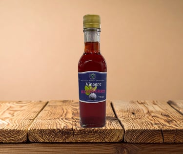 Una botella de 250 ml de vinagre de arándanos artesanal sobre una mesa de madera rústica.
