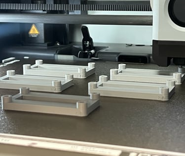 Batch production of custom 3D printed components and brackets on an industrial FDM 3D printer bed.