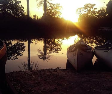 A tranquil view of the Marakissa River Camp, showcasing safari-style tents and rustic cabins situate