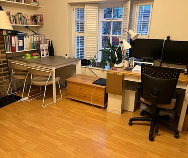 Existing home office with a lot of clutter on display
