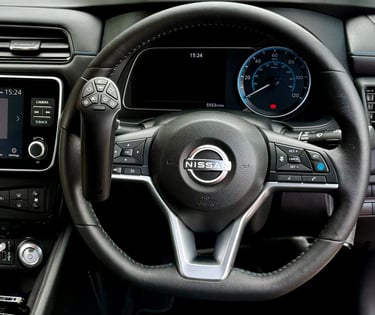 A Nissan steering wheel with a mounted steering ball hand control for disabled drivers.