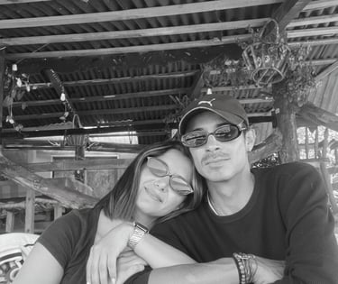  Fotografía en blanco y negro de una pareja linda con gafas de sol sentada en una mesa de patio 