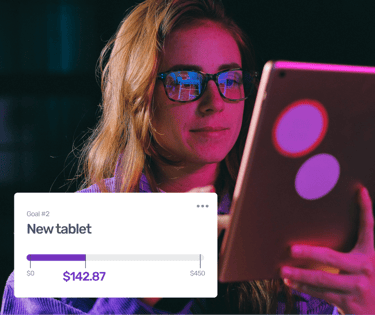 A woman tracking her savings progress for a new tablet using a mobile finance app budget tracker.