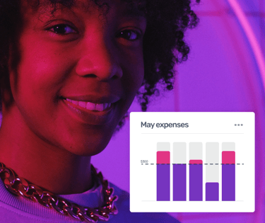 Smiling woman with curly hair viewing a digital budget tracking bar chart for monthly expenses.