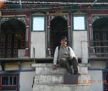 a man sitting on a ledge in front of a building