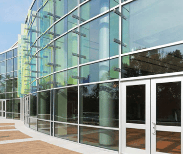 a building with a glass wall and a clock on the outside