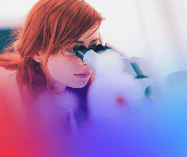 Patologista veterinária olhando no microscópio.