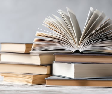 a stack of books with a book open on top of them