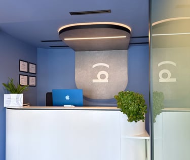 Recepción de la Clínica Bocarriba en Costa del Silencio, con un mostrador blanco y paredes azules