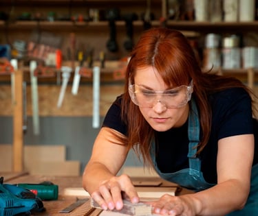 a woman in a blue apron and glasses is making a pottery pottery pottery pottery pottery