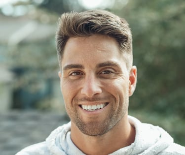 man with thick brown hair smiling