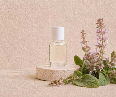 Salvia sclarea flowers and leaves beside pale yellow clary sage essential oil