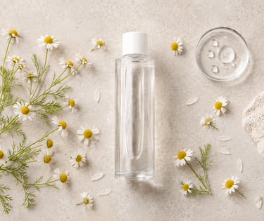 German chamomile water bottle surrounded by white Matricaria chamomilla flowers