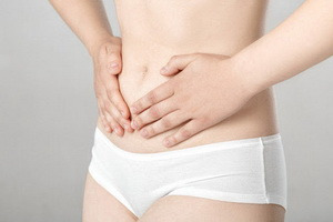 фото жінка тримається за живіт