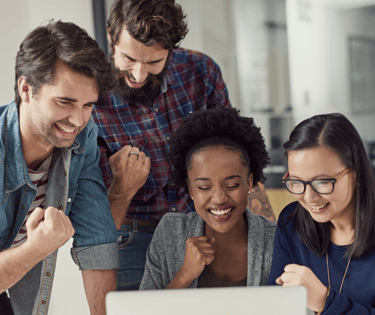 A team celebrating success looking at a computer screen at their achievement