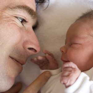 visage d'un père face au visage de son bébé